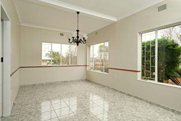 An empty room with a chandelier hanging from the ceiling