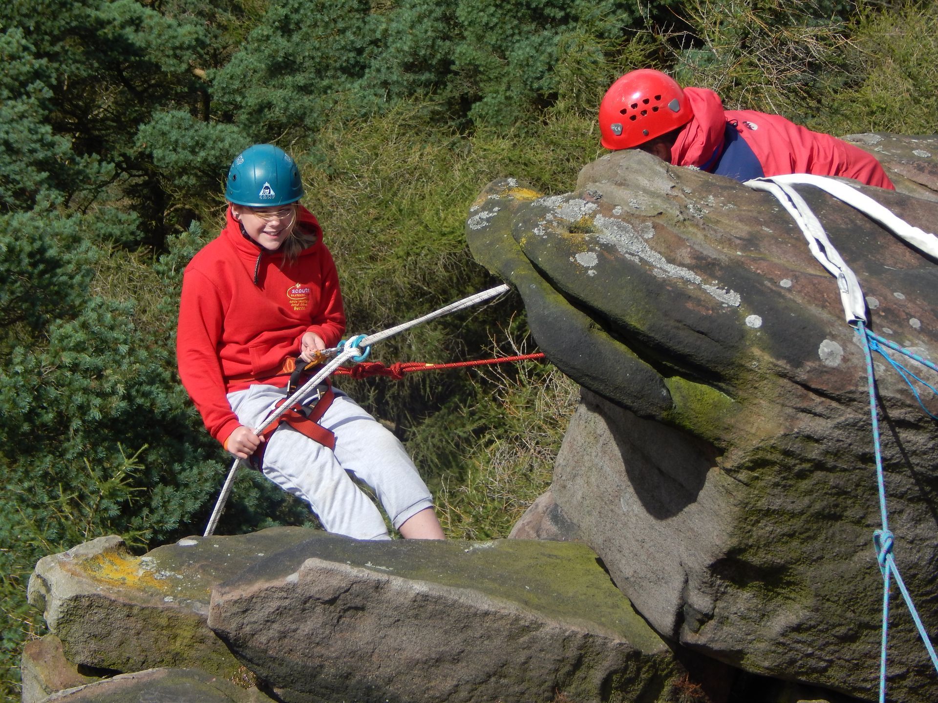 People abseiling down a rock face
