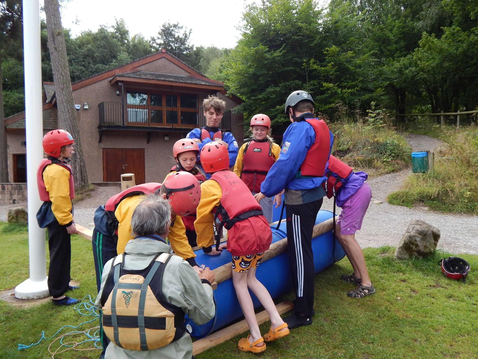 A group of people are standing around a blue raft