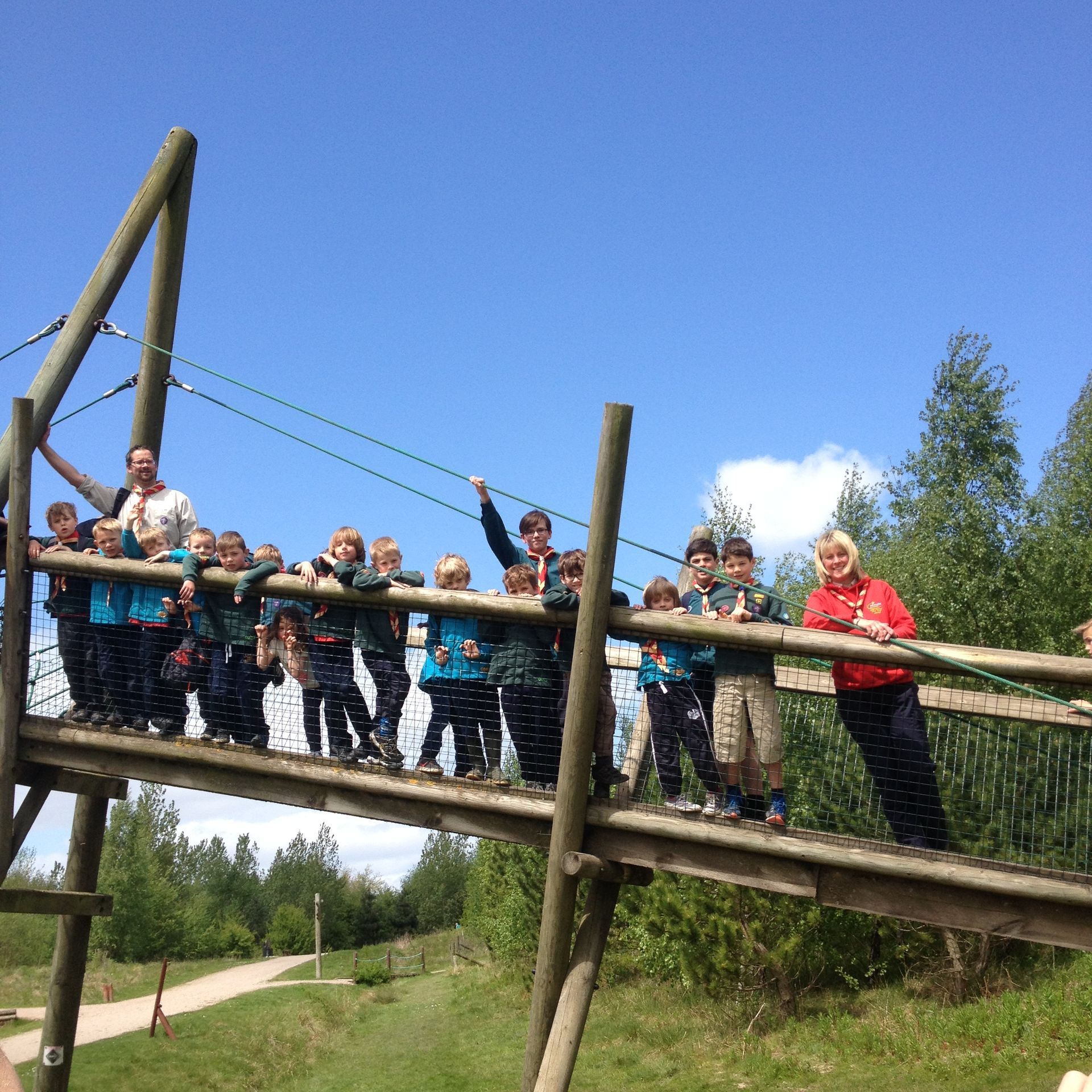 A group of children are standing on a wooden bridge