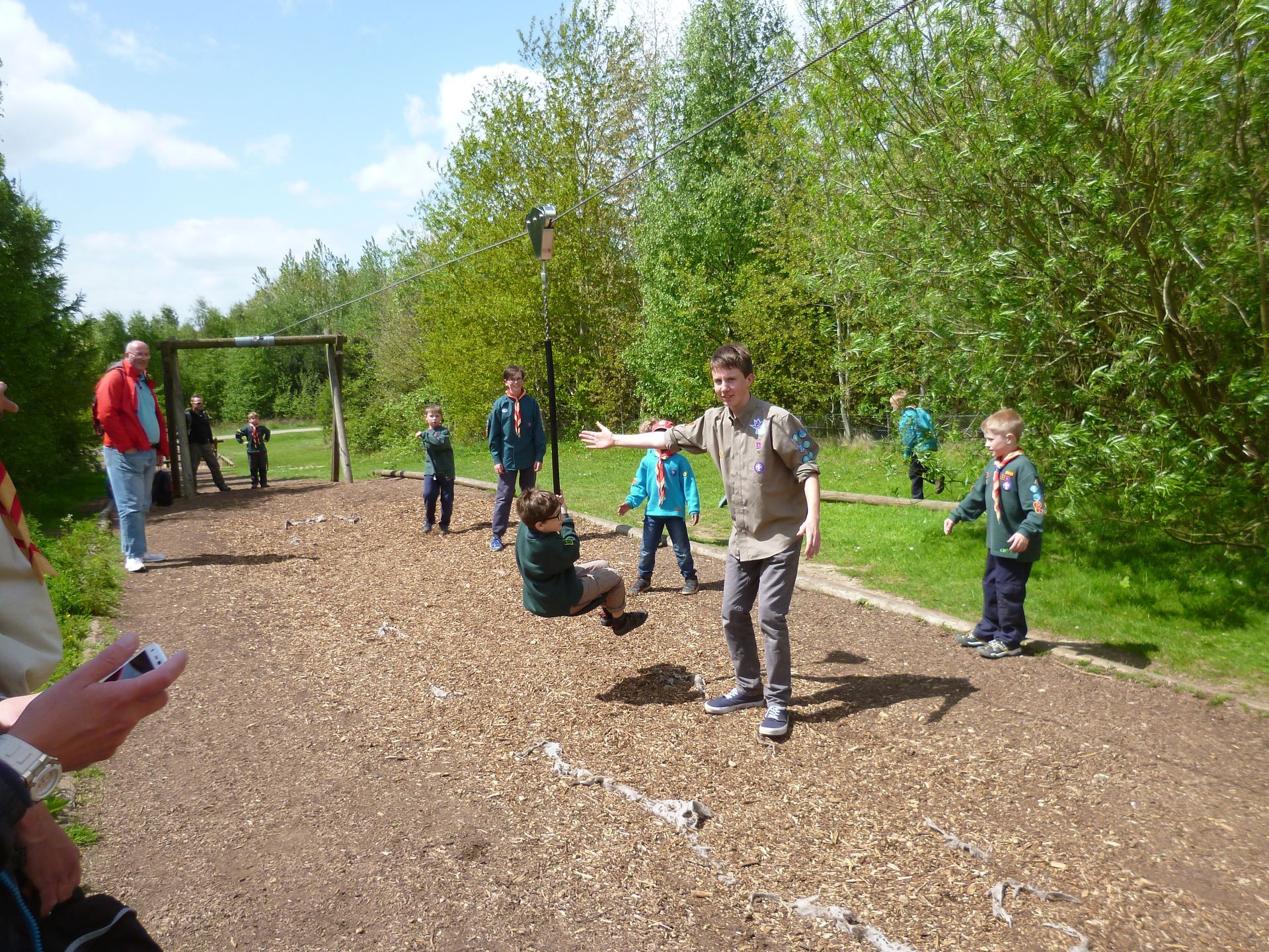 A group of children are playing on a dirt path in a park.