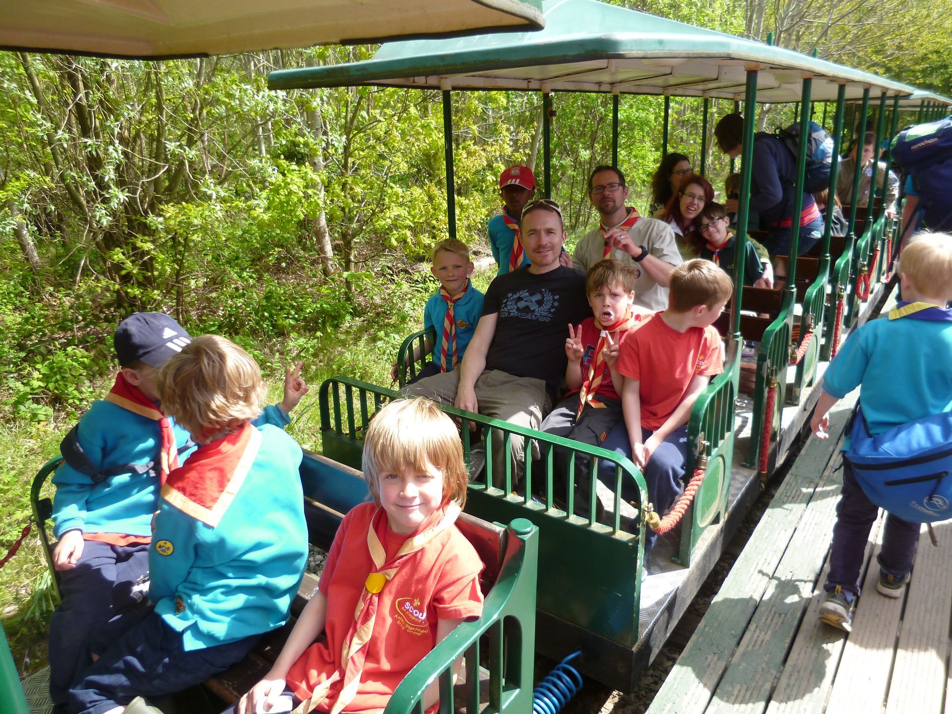 A group of people are riding on a train with a man wearing a t-shirt that says csd