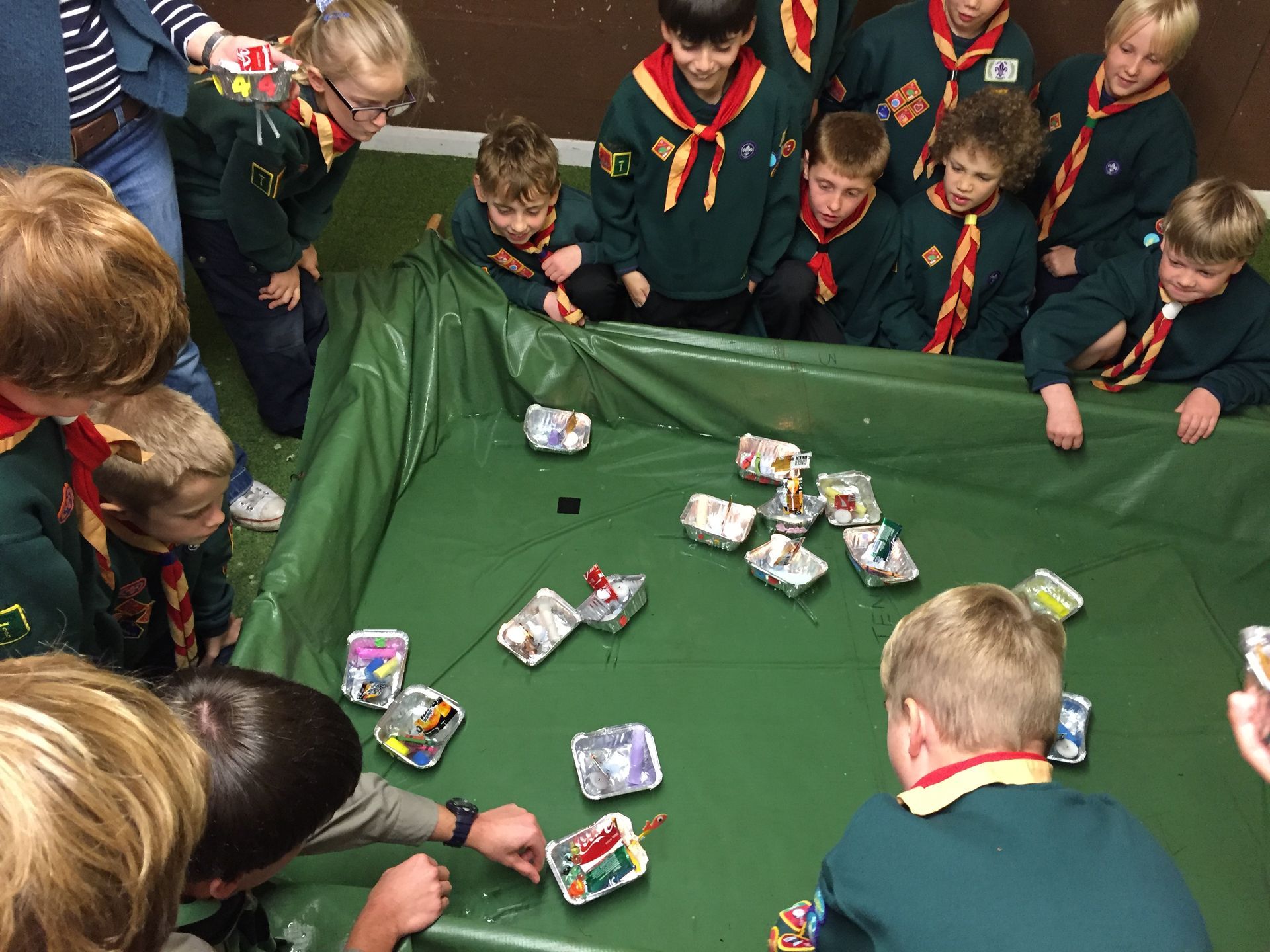 A group of boy scouts are playing a game on a table