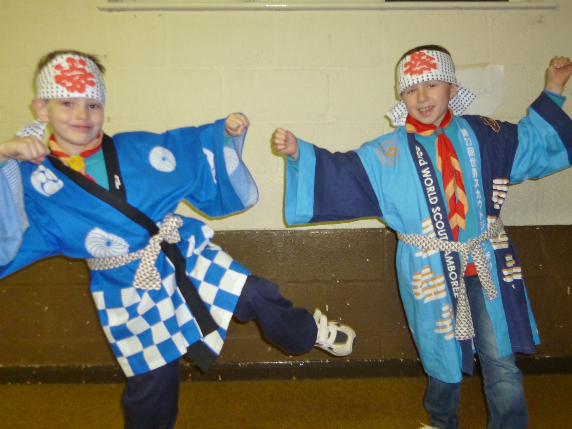 Two young boys wearing blue kimonos with the word scout on them