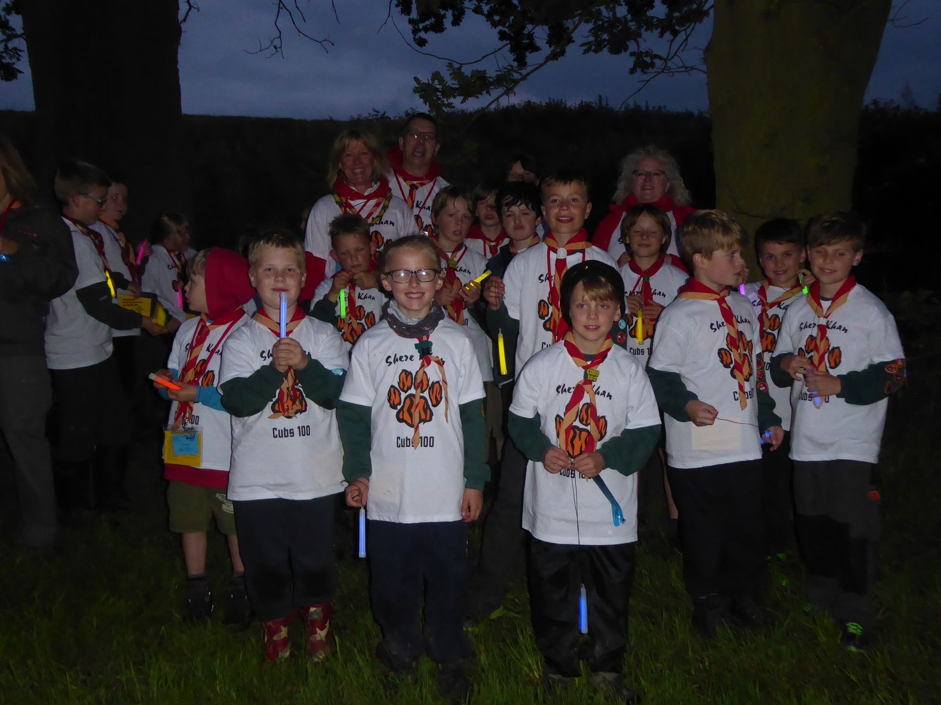 A group of children wearing glow in the dark shirts are posing for a picture