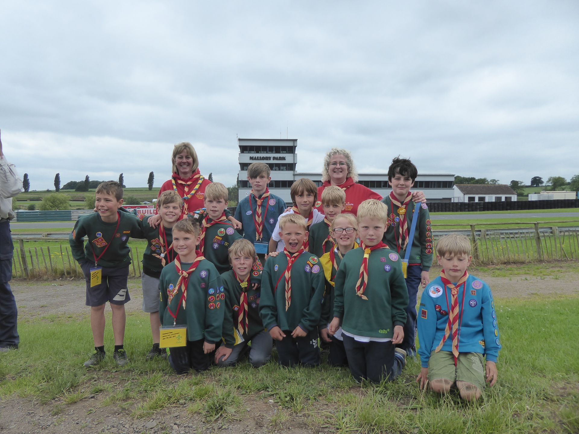 A group of boy scouts posing for a picture in a field