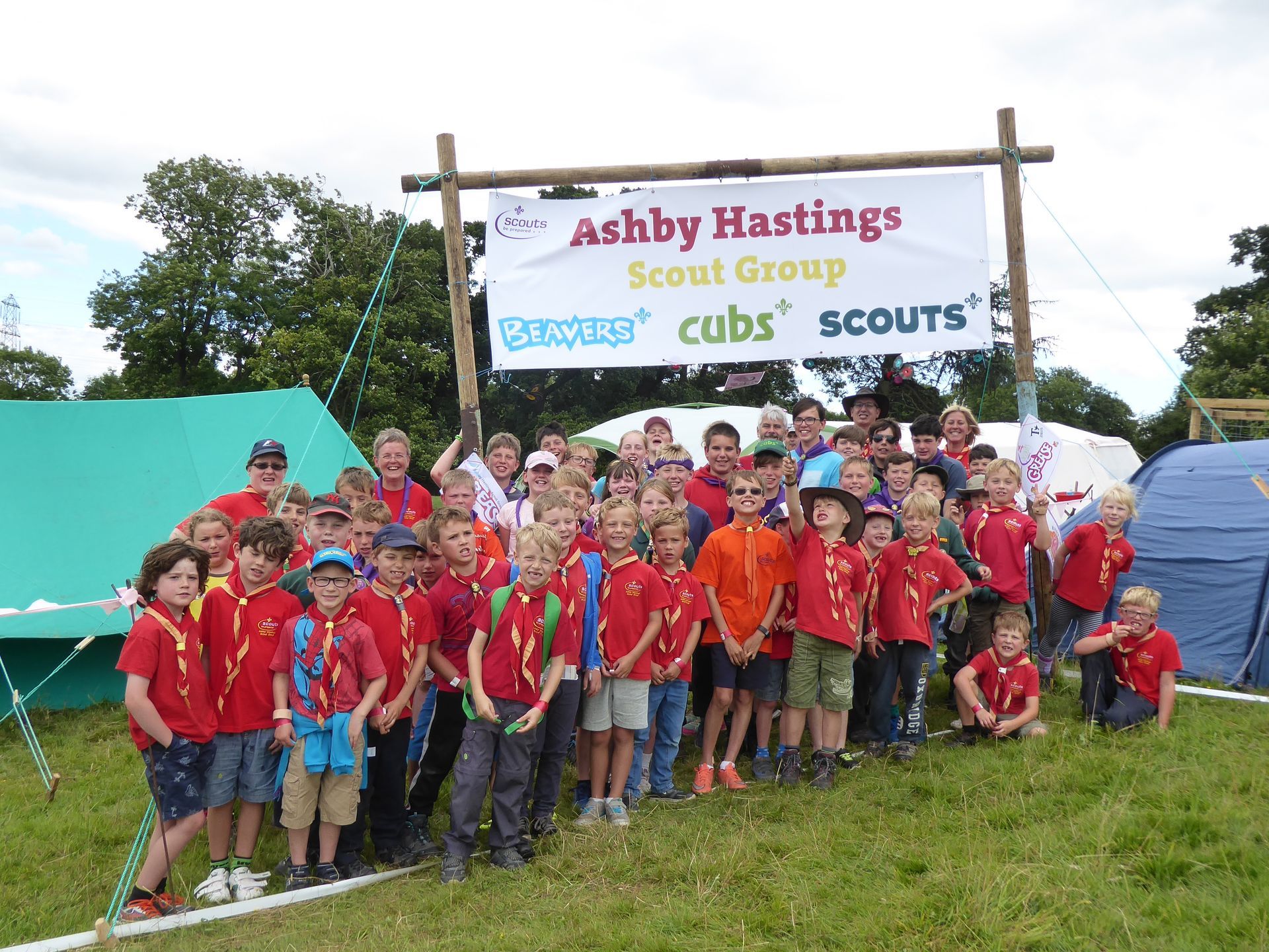 A group of boys standing in front of a sign that says ashby hastings scout group