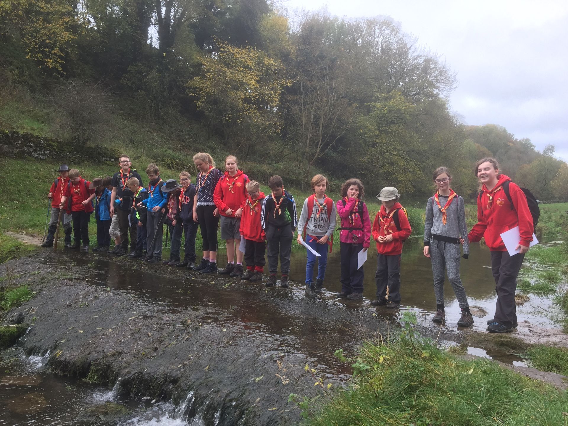 A group of people are standing next to a river.