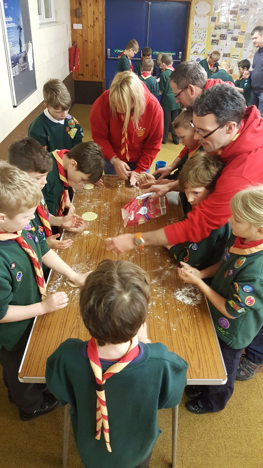 A group of children are sitting around a table in a room.