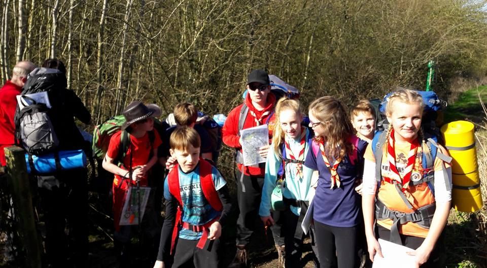 A group of children with backpacks are walking down a path.
