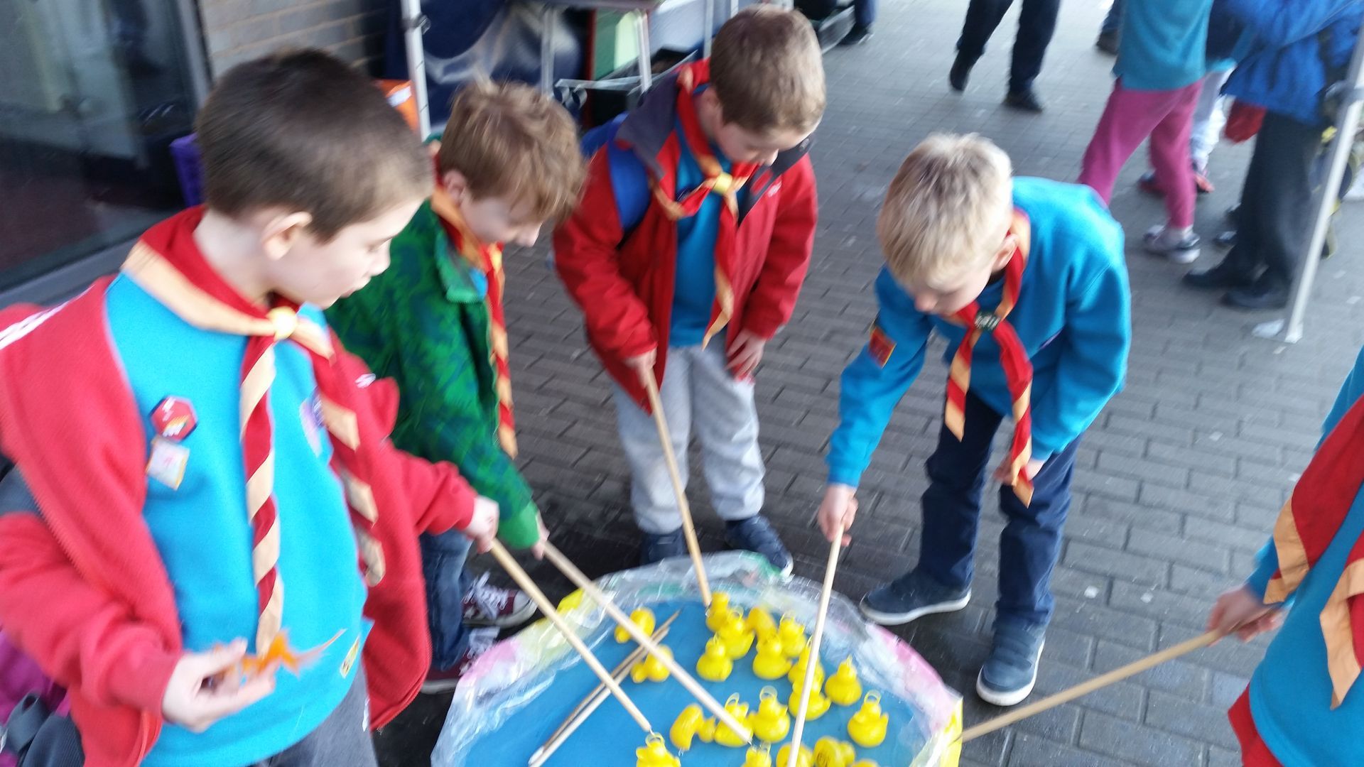 A group of young boys are playing with rubber ducks.