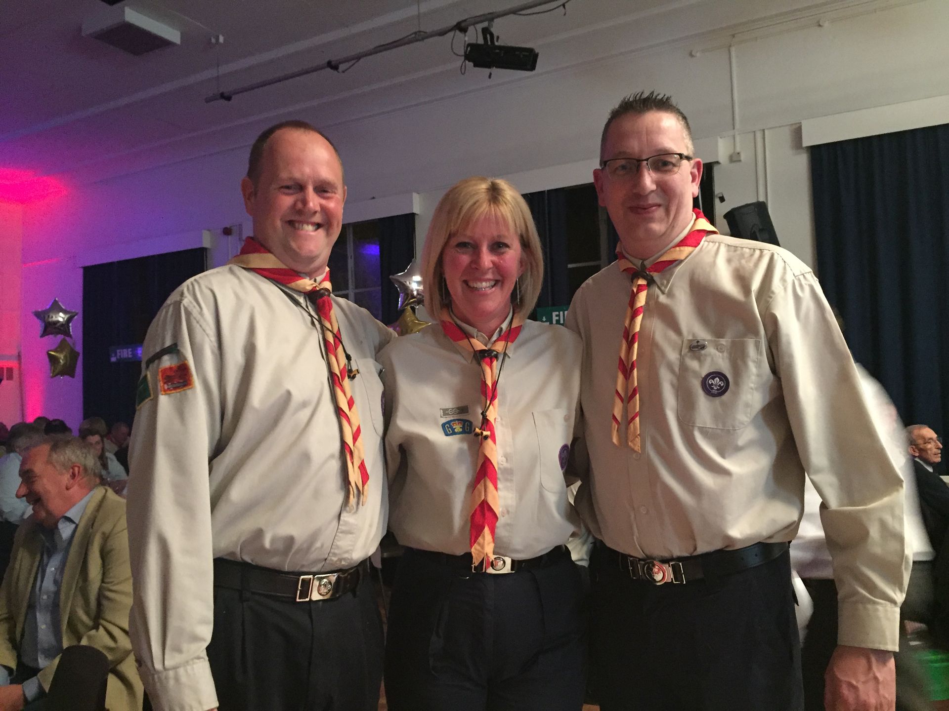 Two men and a woman are posing for a picture together