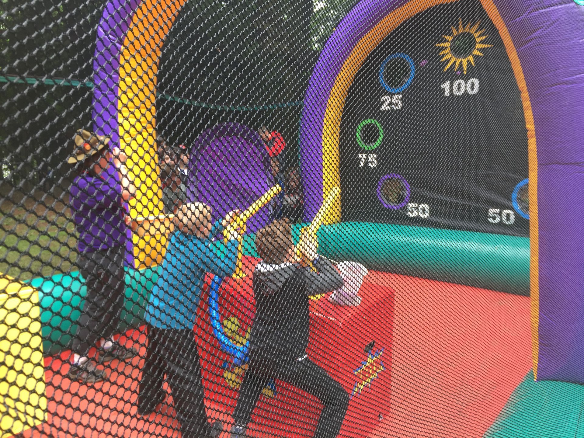 A group of children are playing a game of baseball in a bouncy house.