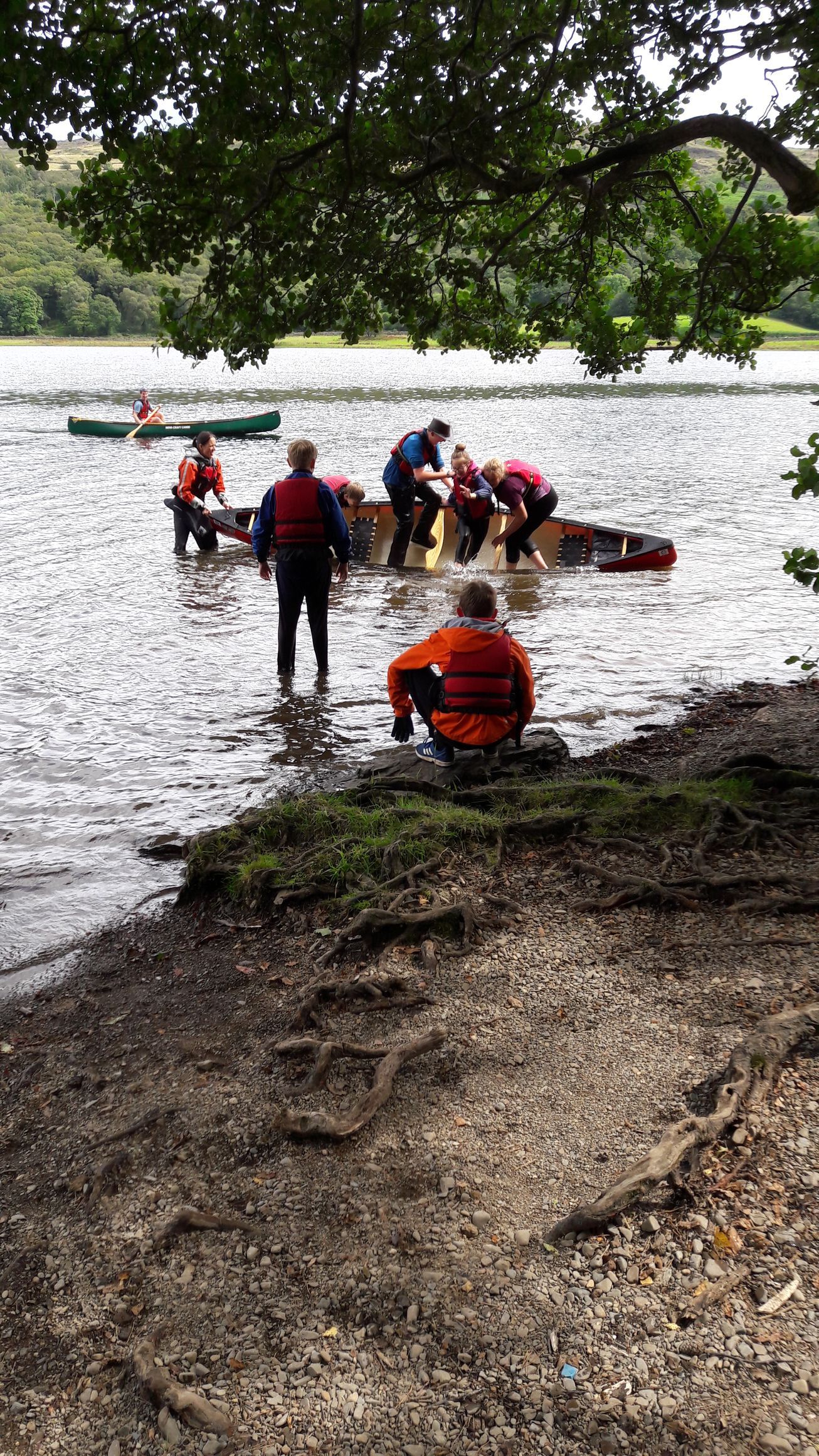 A group of people are rowing a boat in a lake.