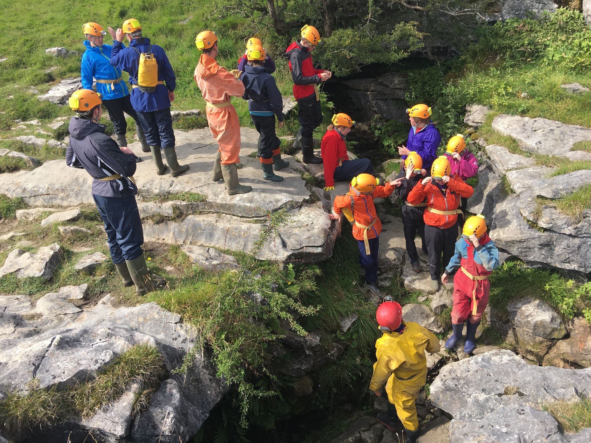 A group of people are standing on top of a rocky hill.