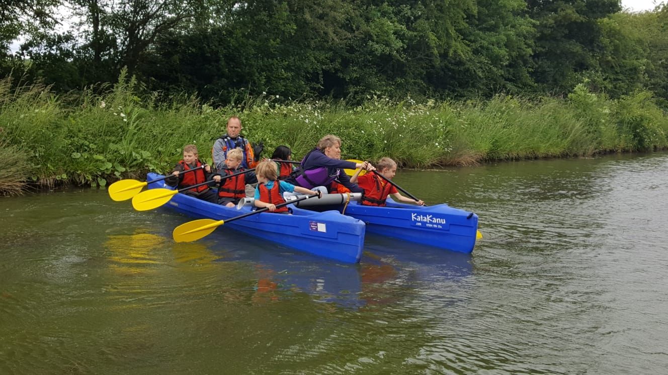 A group of people are rowing kayaks on a river.