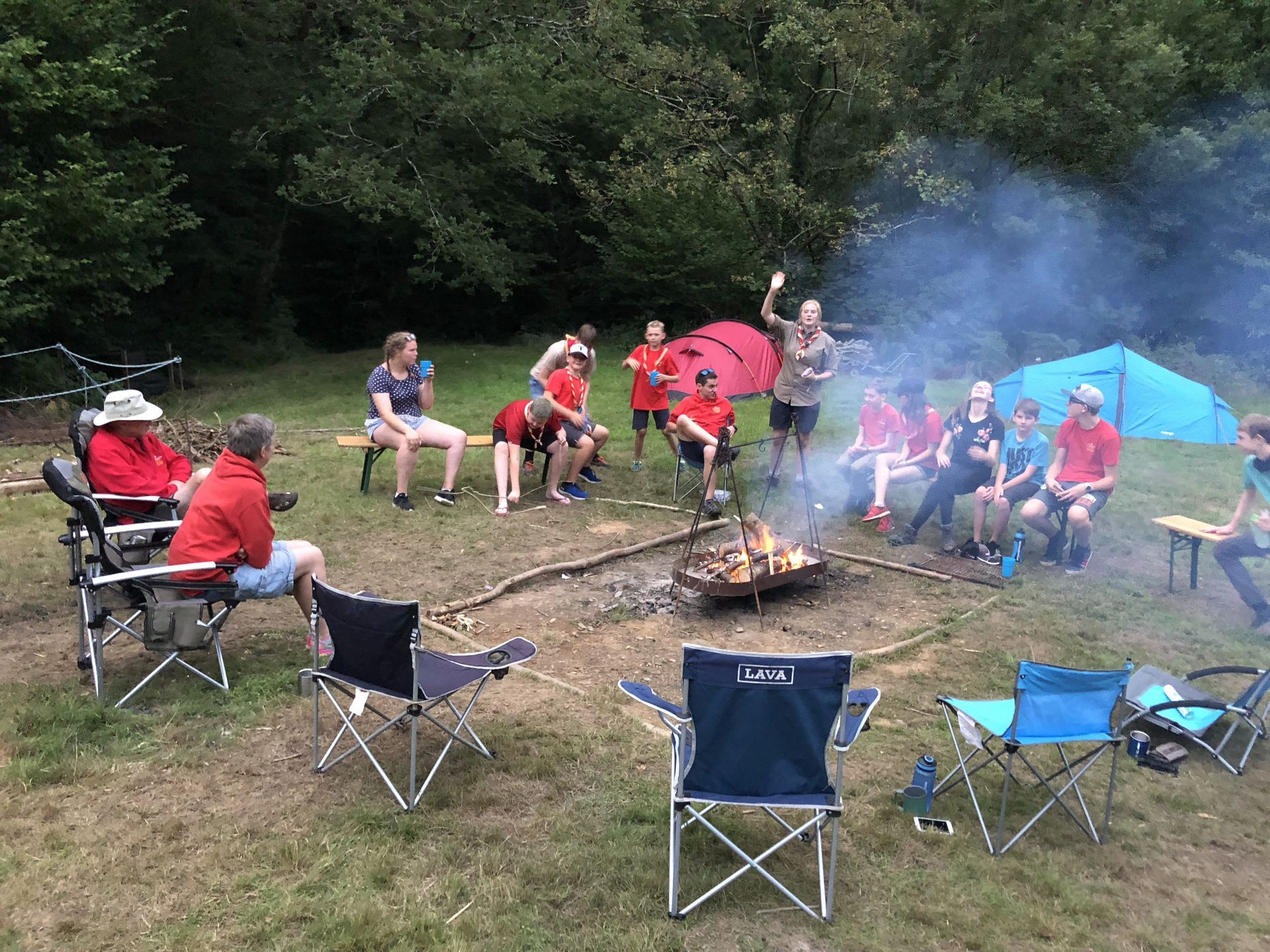 A group of people are sitting around a campfire.