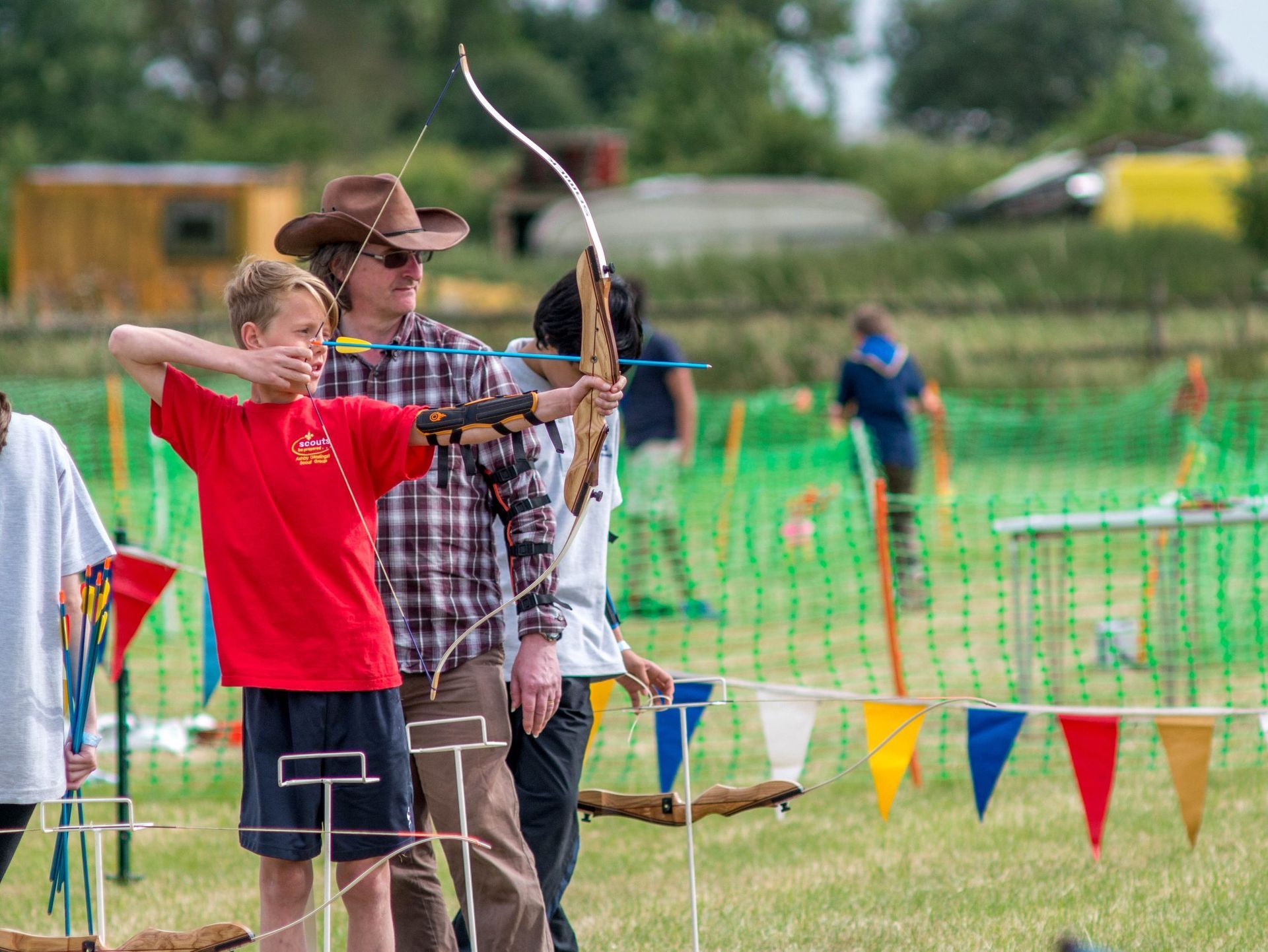 A group of people are playing archery in a field.