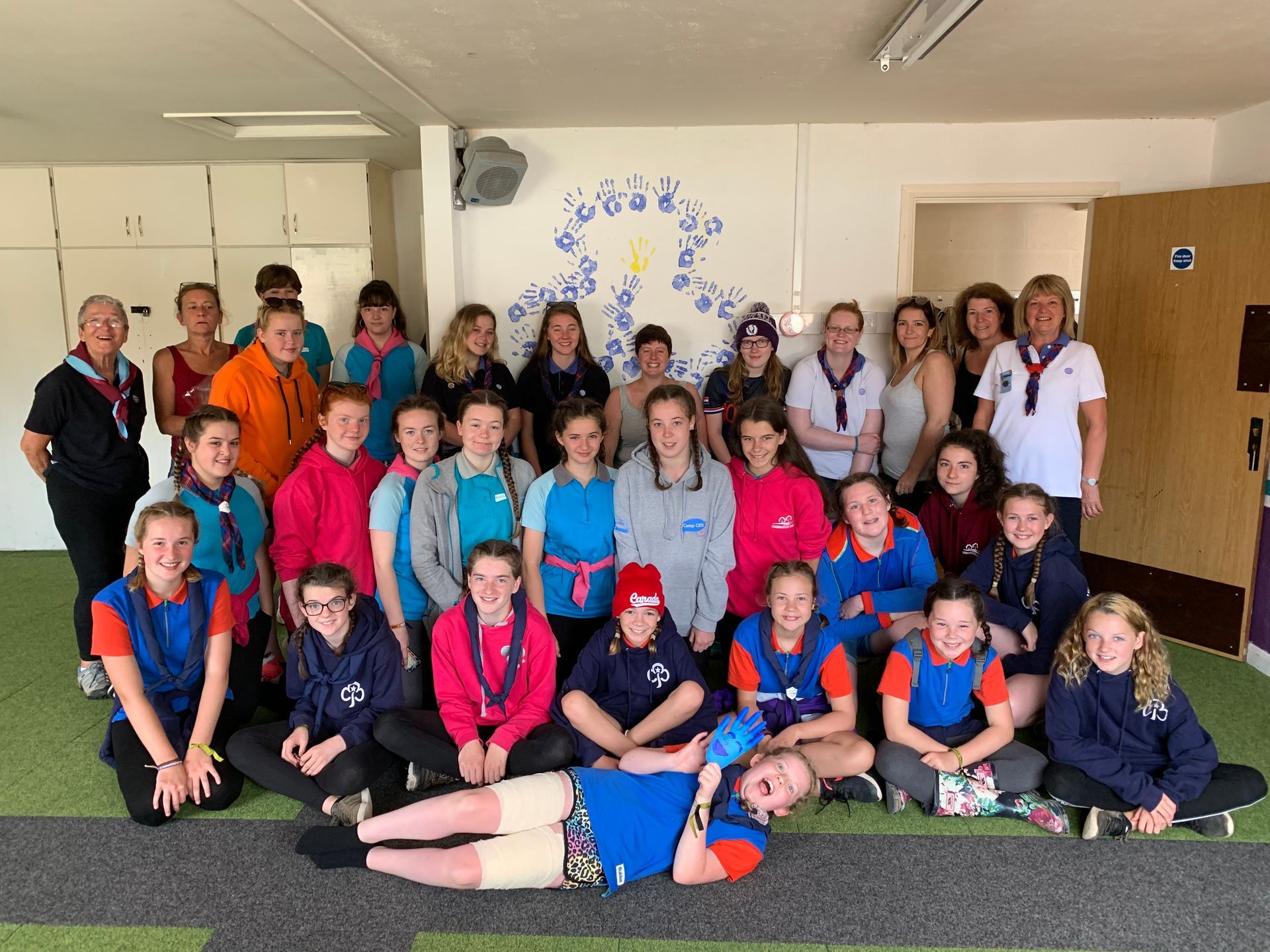 A group of young people are posing for a picture in a room.