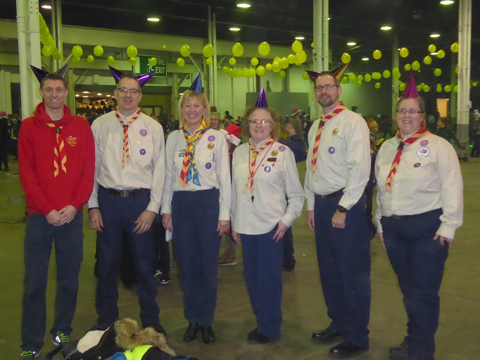 A group of people wearing party hats are posing for a picture