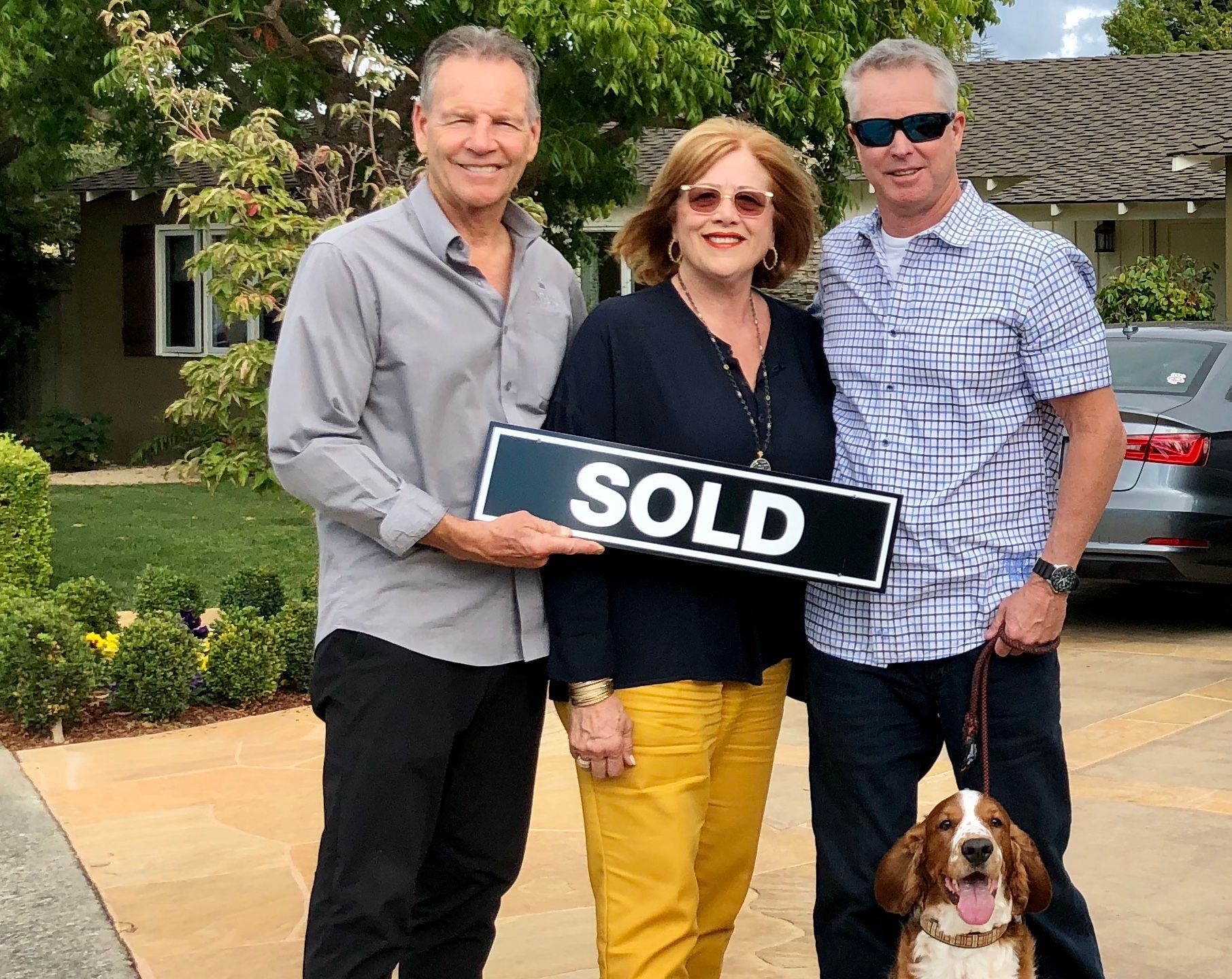 Donna and Barney with a home seller holding a sold sign