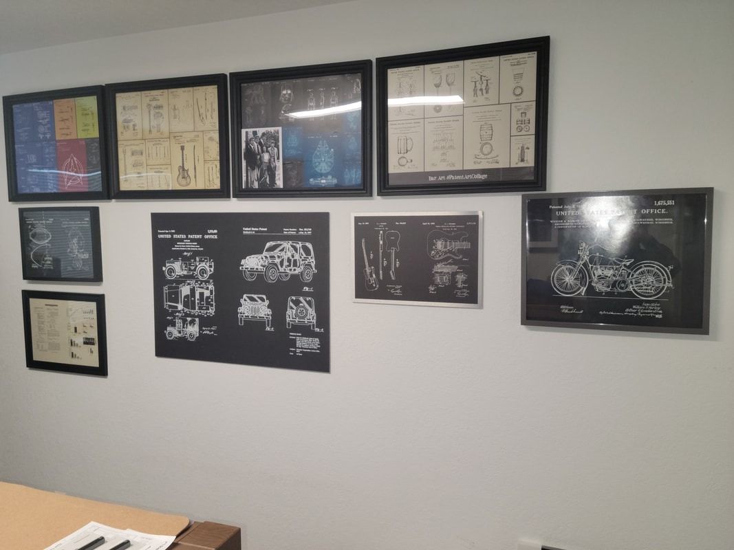 Framed technical drawings and black-and-white sketches arranged in two rows on a white wall.