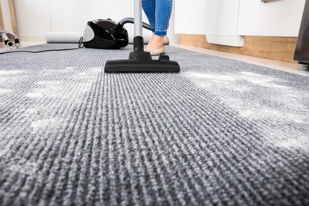 Woman is Using a Vacuum Cleaner to Clean a Carpet — Capital Ultimate Facility in Tuggeranong, ACT