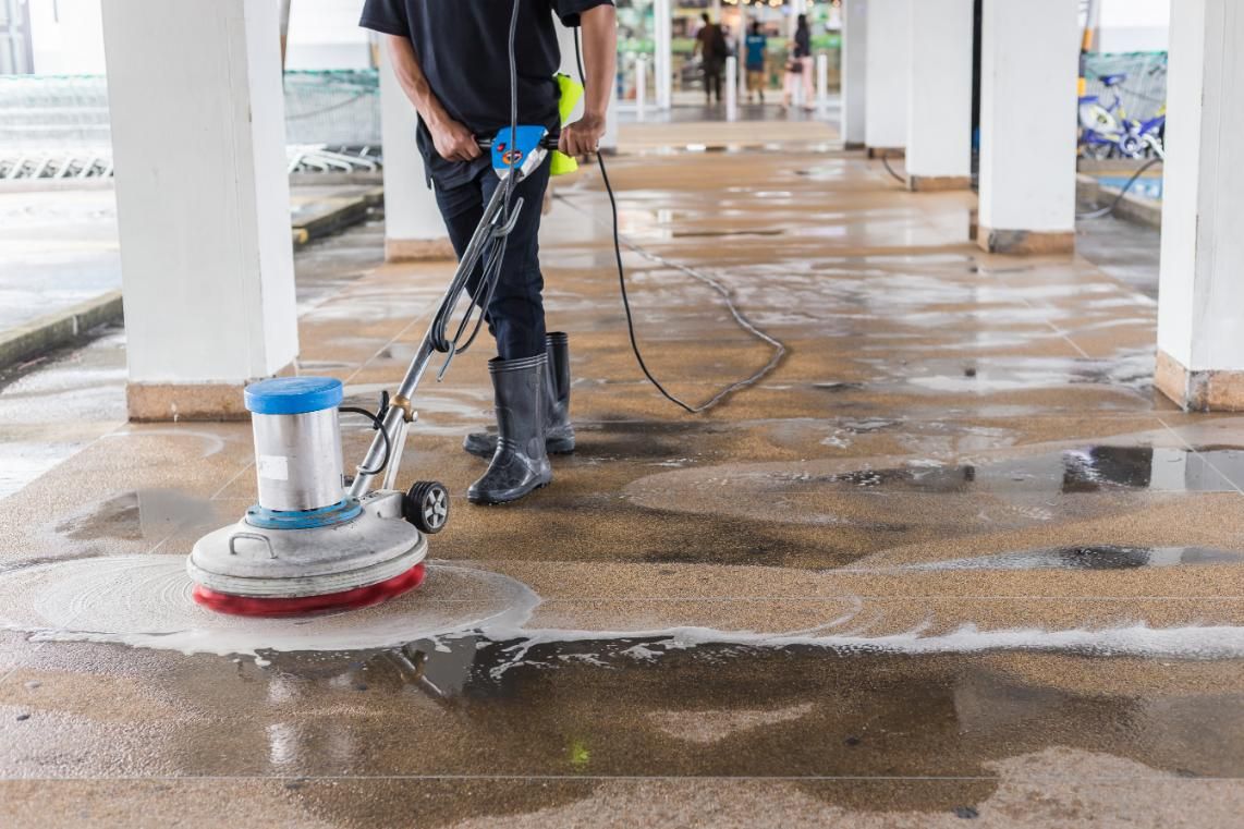 Man is Cleaning a Concrete Floor With a Machine — Capital Ultimate Facility in Queanbeyan, NSW