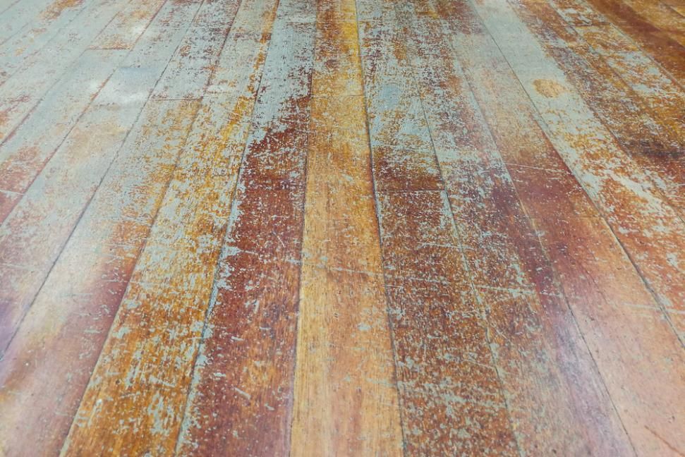 A close up of a wooden floor with peeling paint. — Capital Ultimate Facility in Tuggeranong, ACT