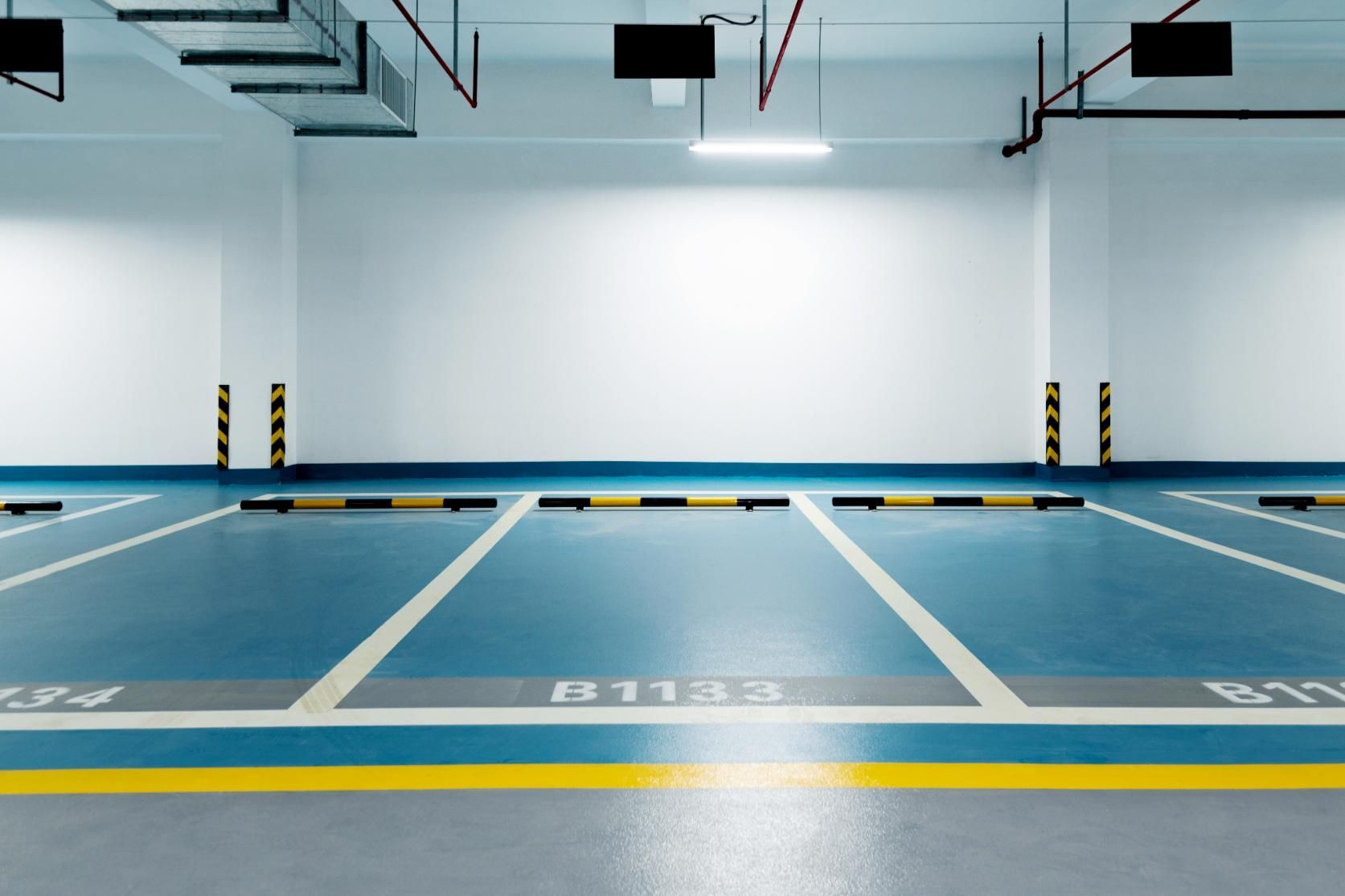 An Empty Parking Garage With a Blue Floor and White Lines — Capital Ultimate Facility in Beard, ACT