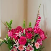 Pink and white floral bouquet with roses and tall blossoms in a vase