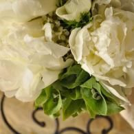 White flowers with green leaves on a decorative wrought-iron background