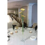 Dining table set for a formal event, with white tablecloth, candles, and a tall vase of yellow flowers.