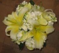 Yellow and white floral bouquet with lilies and baby’s breath on a brown background