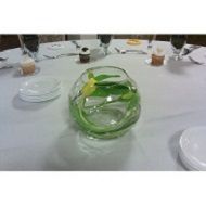 Clear glass bowl with green leaves on a white table setting
