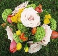 Colorful floral wreath with white, pink, green, and yellow flowers on grass
