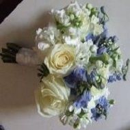 White and blue bridal bouquet with cream roses and green foliage