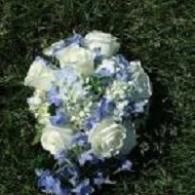 White and blue floral bouquet on dark green foliage backdrop