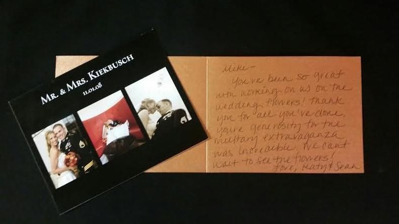 Black card with three small photos beside a handwritten orange note on a dark surface.