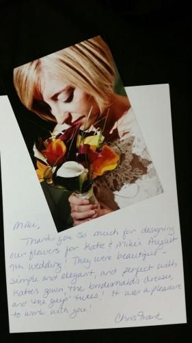 Handwritten condolence card with a photo of a woman holding flowers on a black background