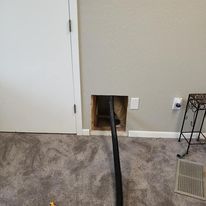 A room with a hole in the wall and a pipe coming out of it.