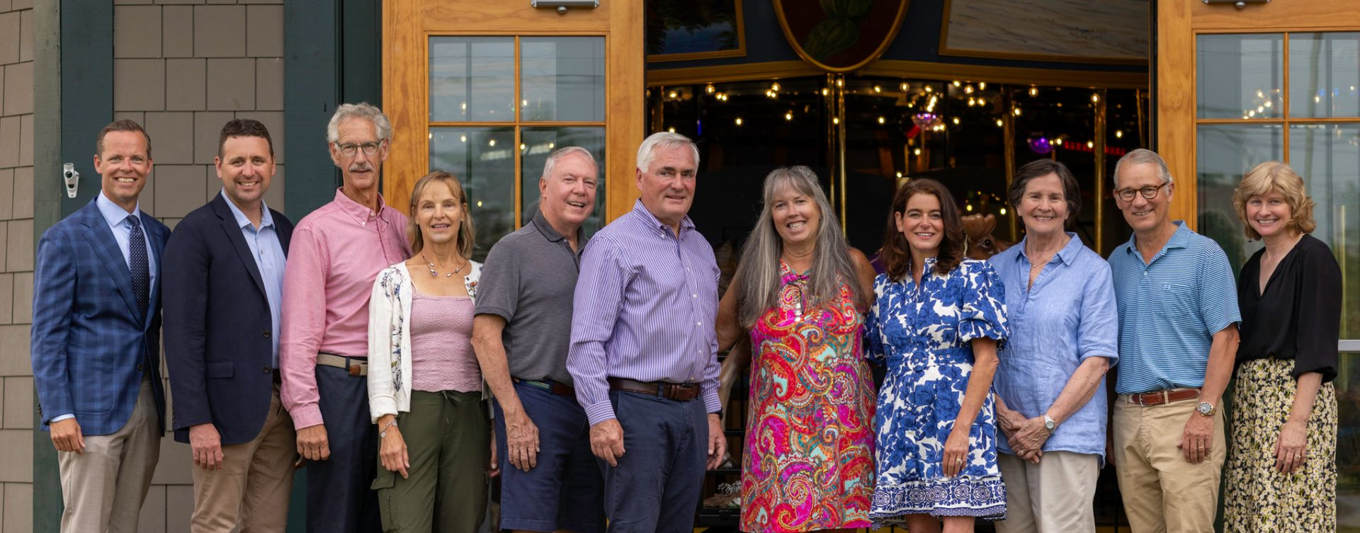 A group photo of the board of directors outside the Adirondack Carousel 