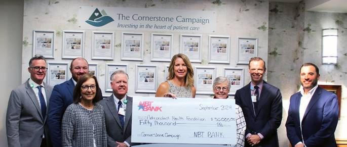 A group of people holding a large check, celebrating a donation to the Cornerstone Campaign