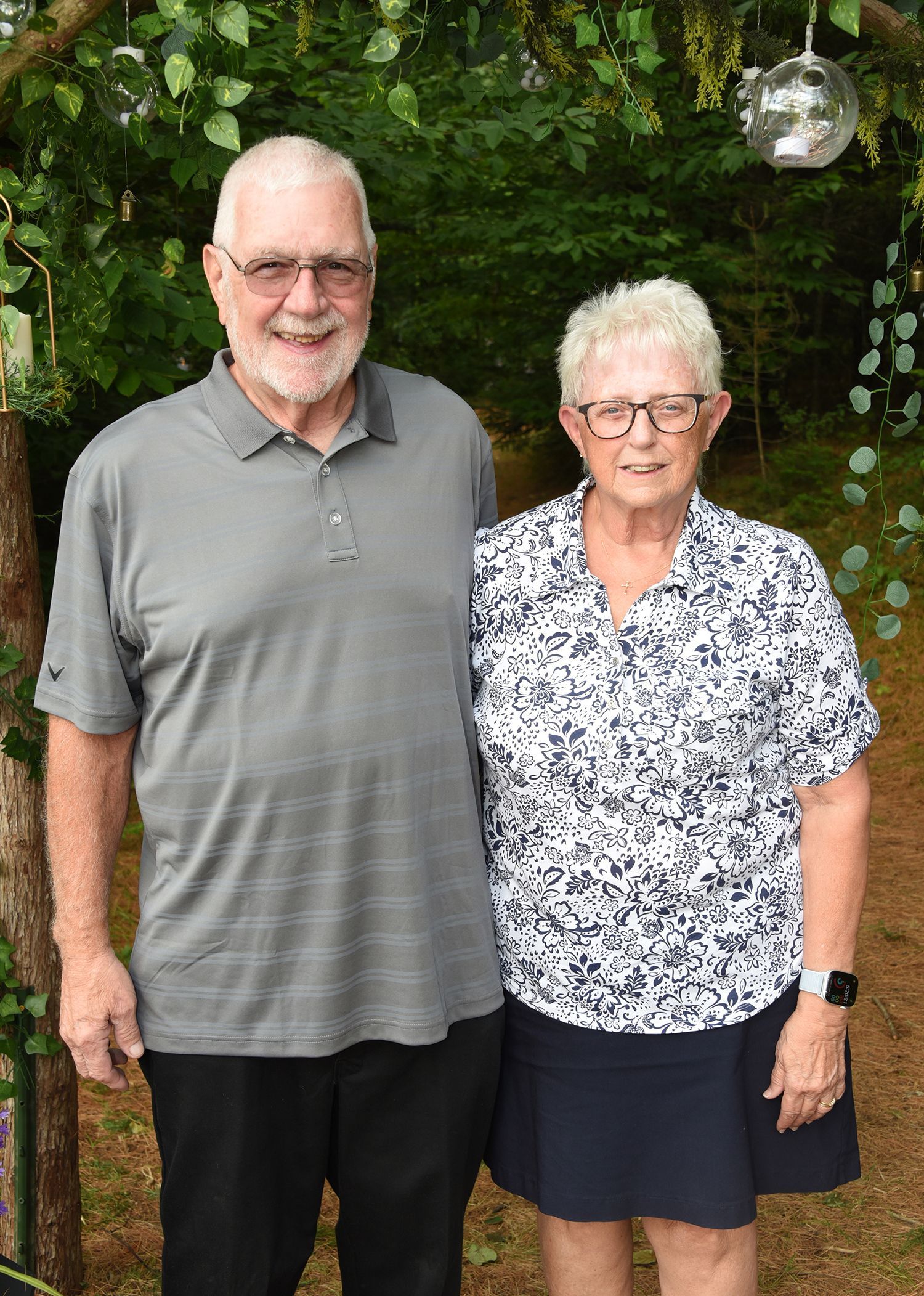 An older couple standing together outdoors. 