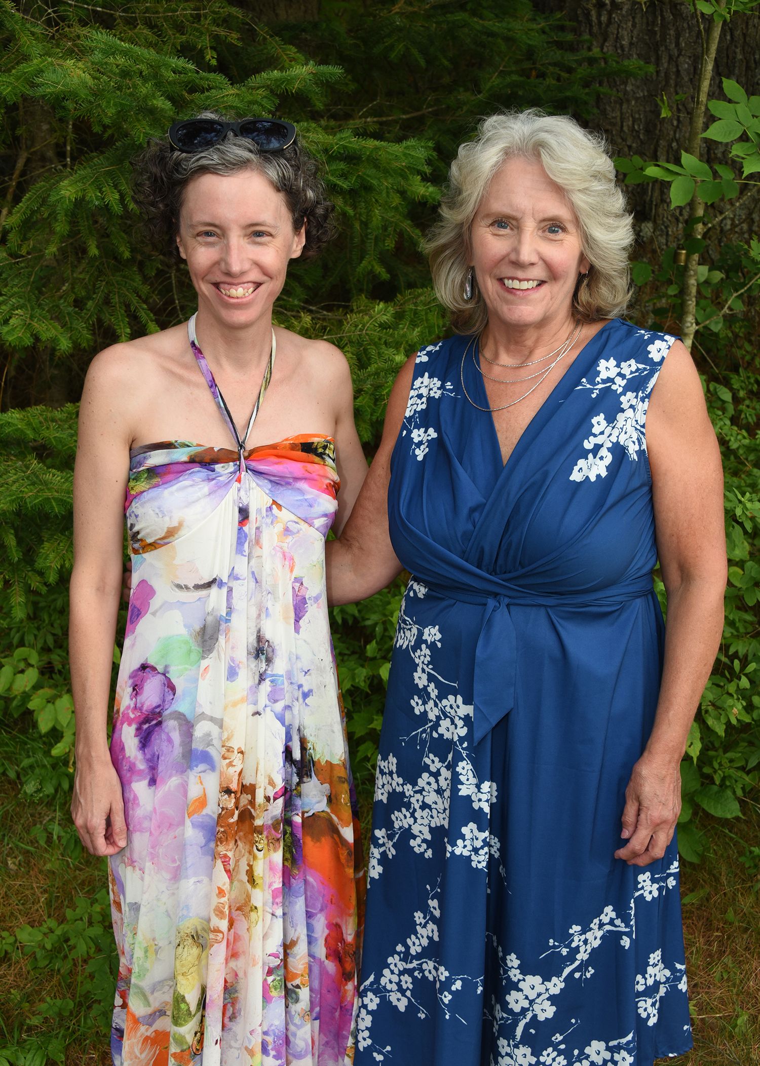 Two women pose outdoors.