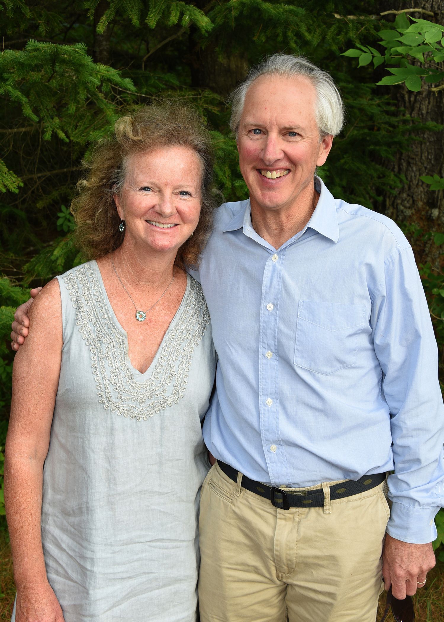A smiling older couple standing together outdoors.
