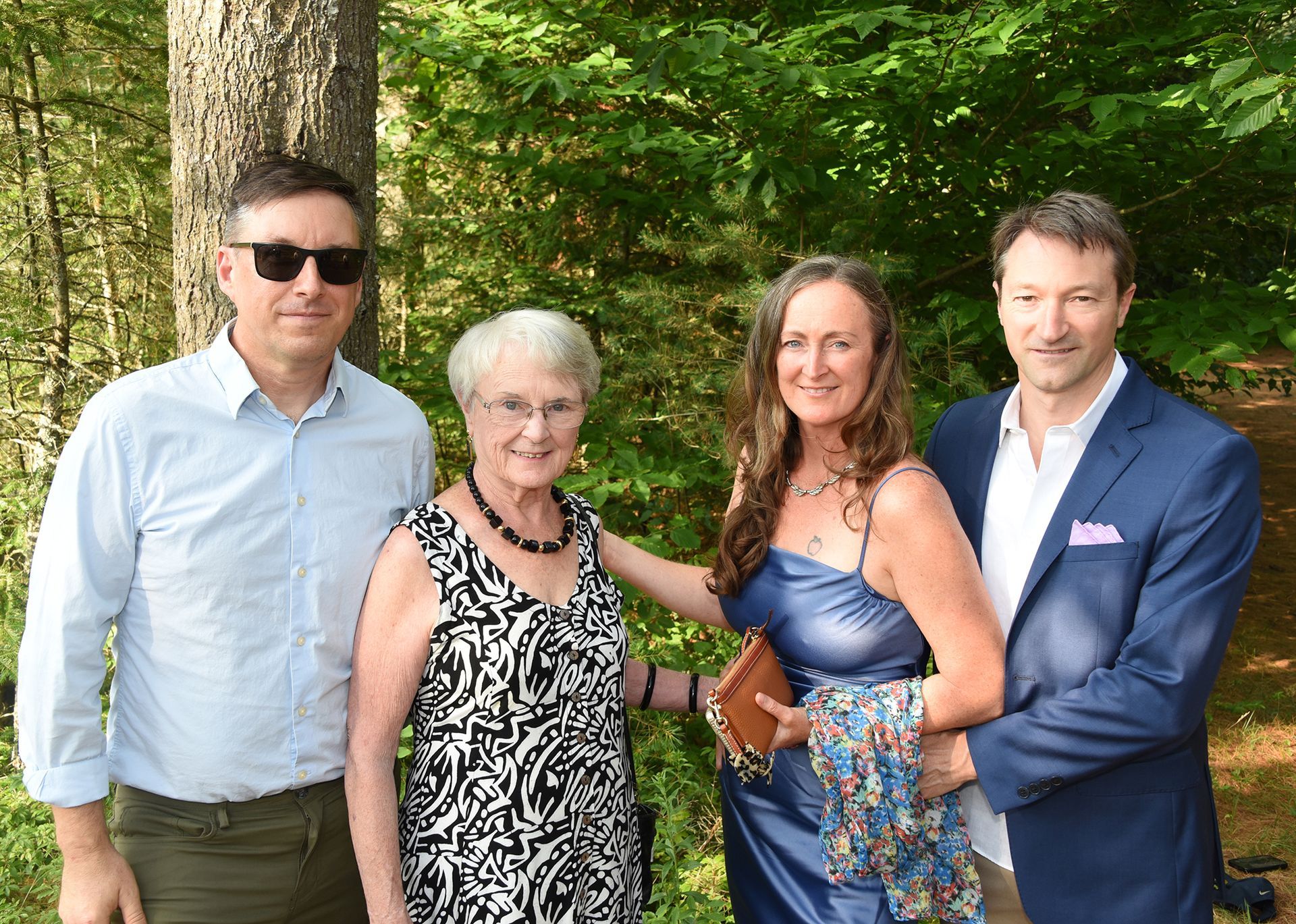 Group of four people posing outdoors: two men and two women.