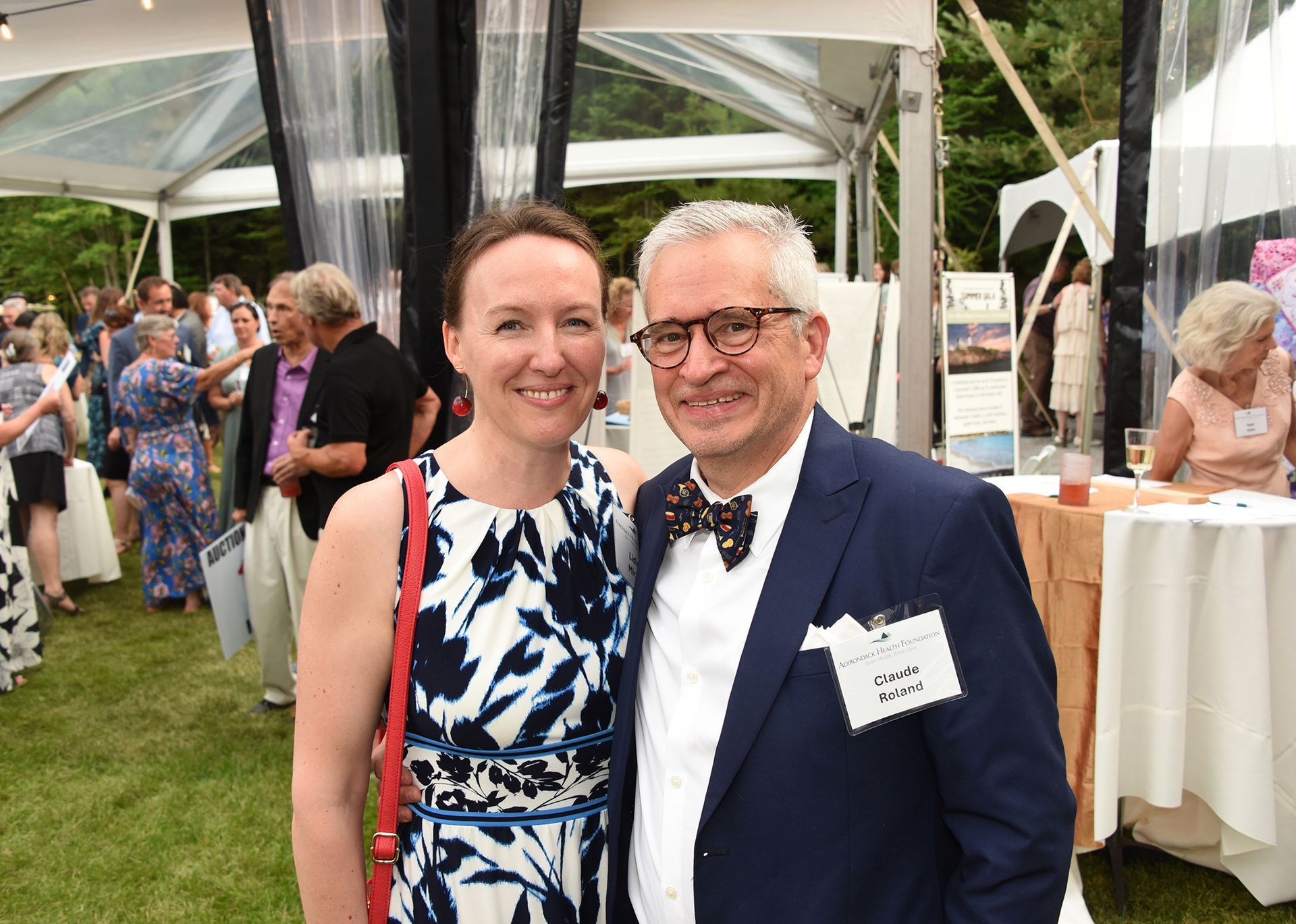 Two people smiling for the camera at an outdoor event. 