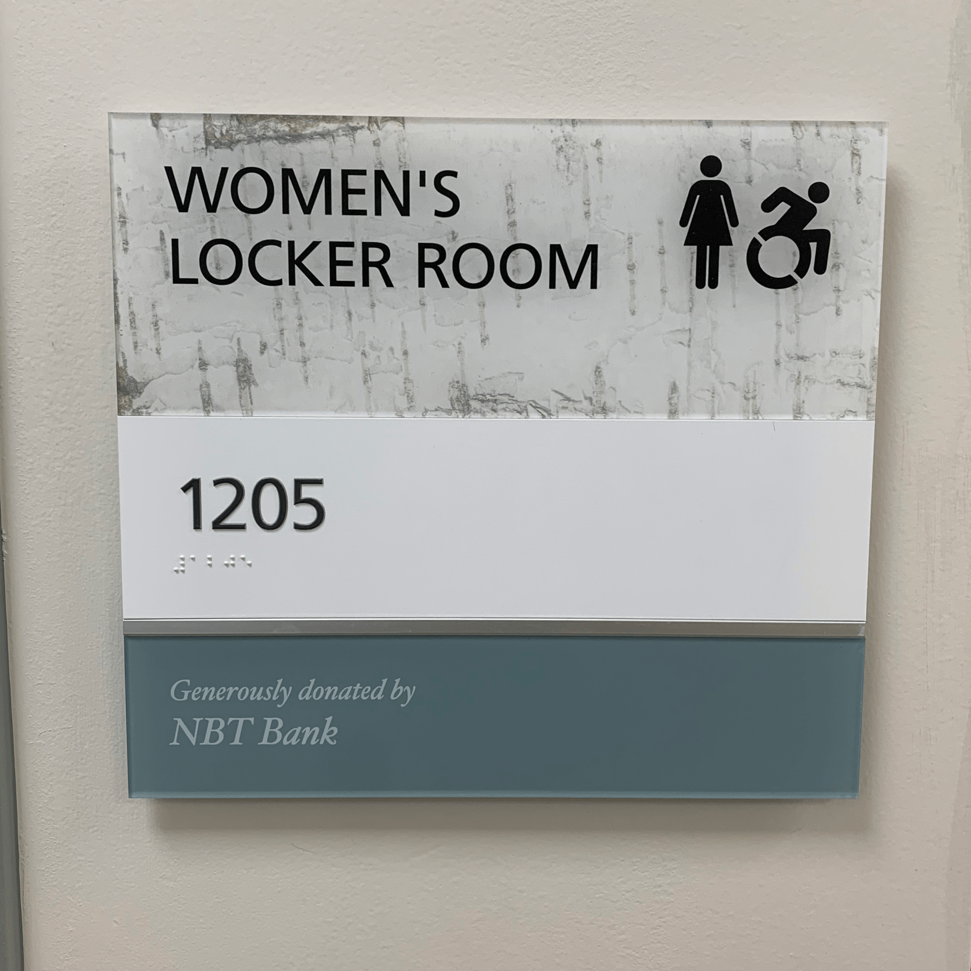Sign for women's locker room donated by NBT Bank.