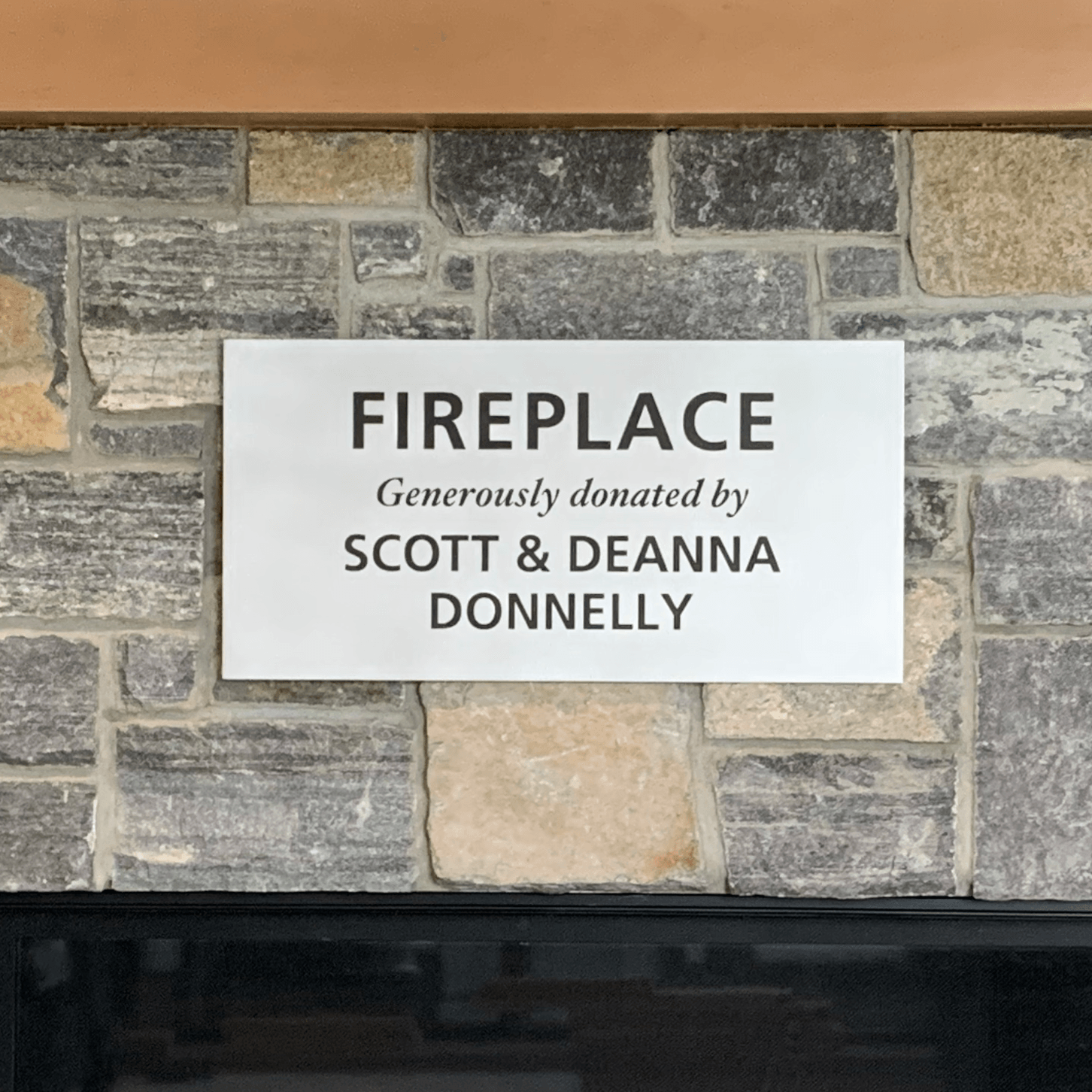 Sign on a stone fireplace reads 
